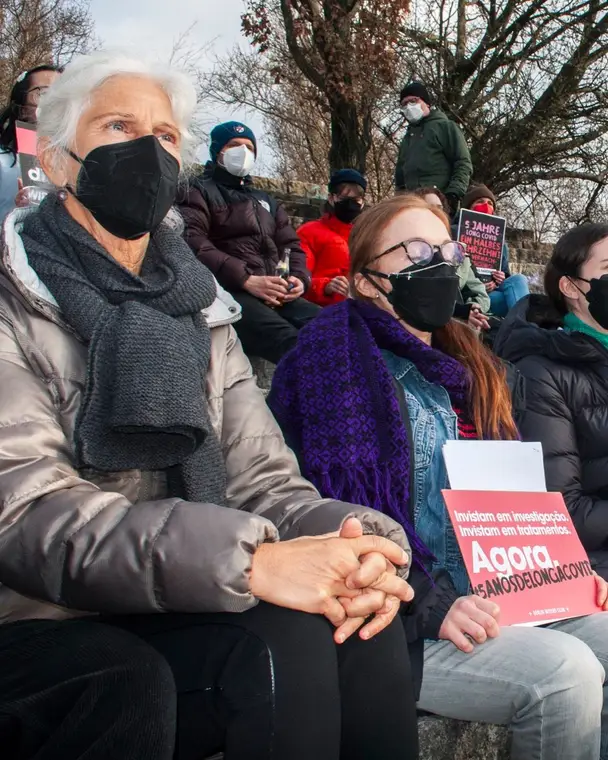 Protesters in masks sitting and listening at Mauerpark